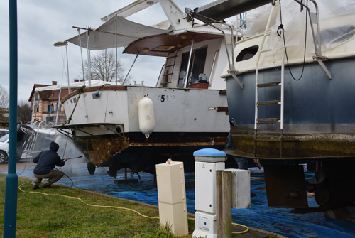 Travaux de réfection après sortie des bateaux. Lavage au karcher